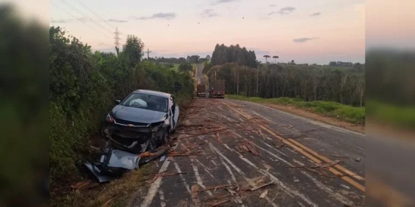 Peça quebra, carga de toras cai de reboque e atinge carro na PR-364